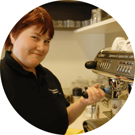 Mitarbeiterin an der Espressomaschine