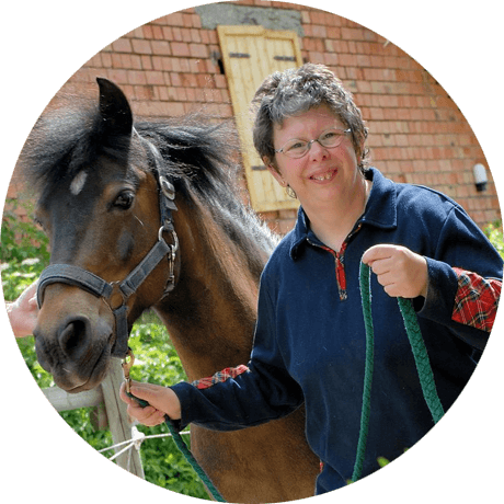 Frau führt ein Pferd