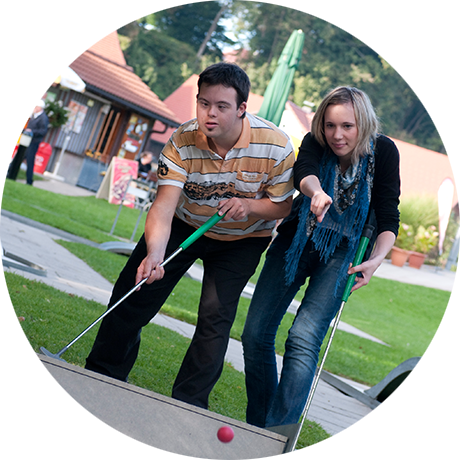 Ein junger Mann und eine junge Frau spielen Minigolf