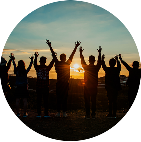 Menschen im Sonnenuntergang halten die Arme nach oben